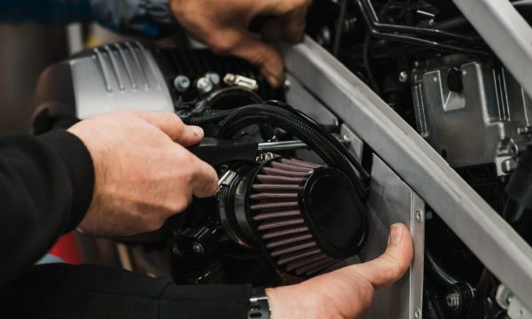 Repairman repair motorcycle, maintenance in garage. Mechanic fixing bike in a modern shop