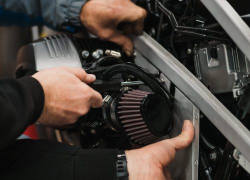 Repairman repair motorcycle, maintenance in garage. Mechanic fixing bike in a modern shop